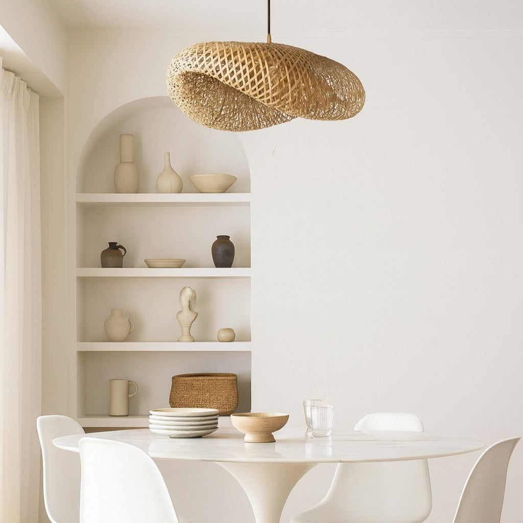 Dining area with a white round table and chairs, wicker pendant light, and shelves with decorative items.